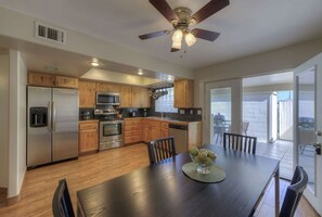 Enjoy cooking in this well-equipped kitchen with a dining area and sliding glass door to an outdoor space.
