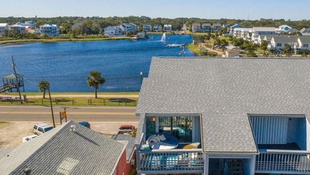 A residential area with a large body of water, houses, and a swimming pool. - Pool! First row from beach front with 2 Private Balconies (Carolina Beach)