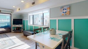 A dining area with a table, chairs, and a decorative vase. - Pool! First row from beach front with 2 Private Balconies (Carolina Beach)