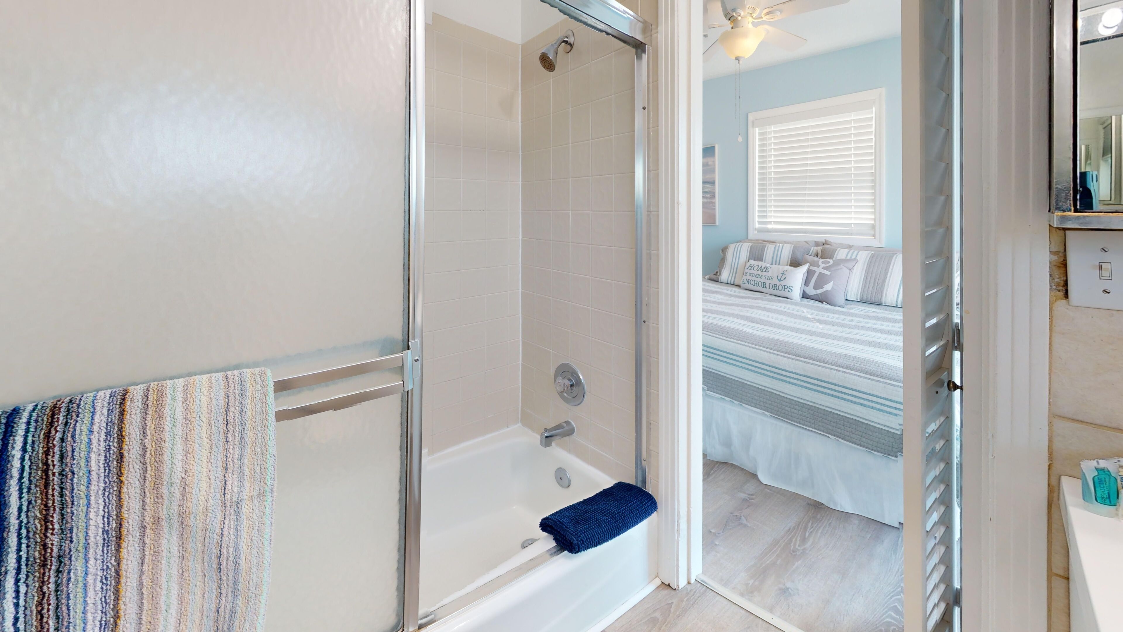 Une salle de bain avec une douche, une baignoire et un porte-serviettes.