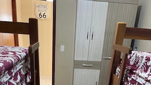 Una habitación pequeña con literas y un armario.