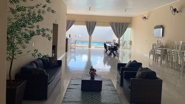 Amplia sala de estar con vista a la playa, amoblada con sofás y una mesa de centro.