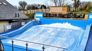 Ein Swimmingpool mit blauer Liegefläche und Holzzaun.