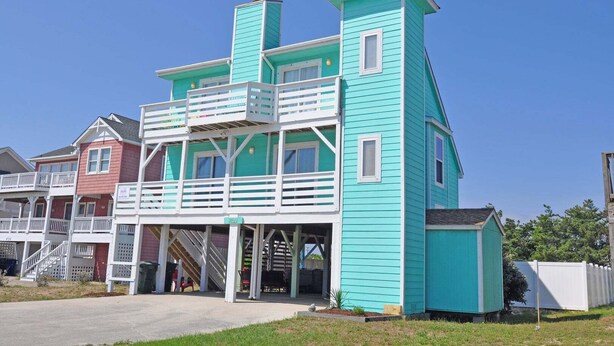 A multi-story building with a balcony, a staircase, and a porch.