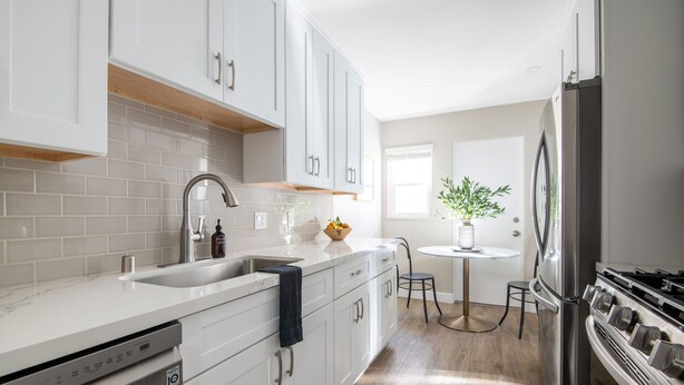 A modern kitchen with white cabinets, a stainless steel refrigerator, and a dishwasher.