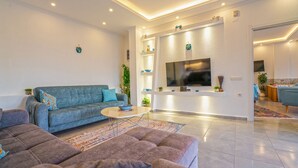 Un salon moderne avec un canapé, une table basse et un téléviseur fixé au mur.