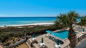 A pool area with lounge chairs and umbrellas, overlooking a beach and ocean. - Gulf Front, Gorgeous Views, Top Floor, Pool, Gated Complex, 30A (Santa Rosa Beach)