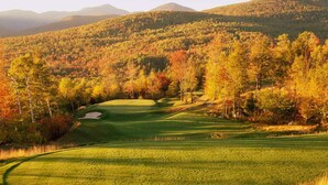 A golf course with a well-maintained fairway, sand bunkers, and a backdrop of autumn-colored trees. - Beautiful Mountain Home - Next to Sunday River (Newry)
