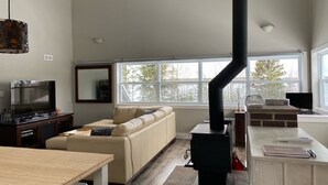 Una sala de estar moderna con chimenea, un sofá, un televisor y un comedor.