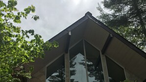 Un bâtiment doté d’une grande baie vitrée et d’une terrasse en bois.