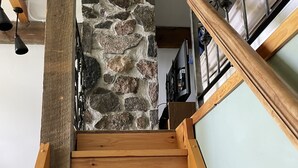 Un escalier en bois avec un mur de pierres en arrière-plan.