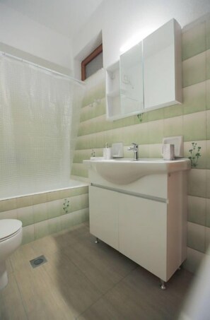 Une salle de bain avec des toilettes, un lavabo et un miroir.