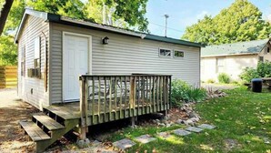 A small, single-story cabin with a front deck and a garage. - Crappie Cabin - Fremont, WI (Fremont)