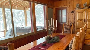 Una sala da pranzo in legno con un lungo tavolo, sedie e un lampadario.