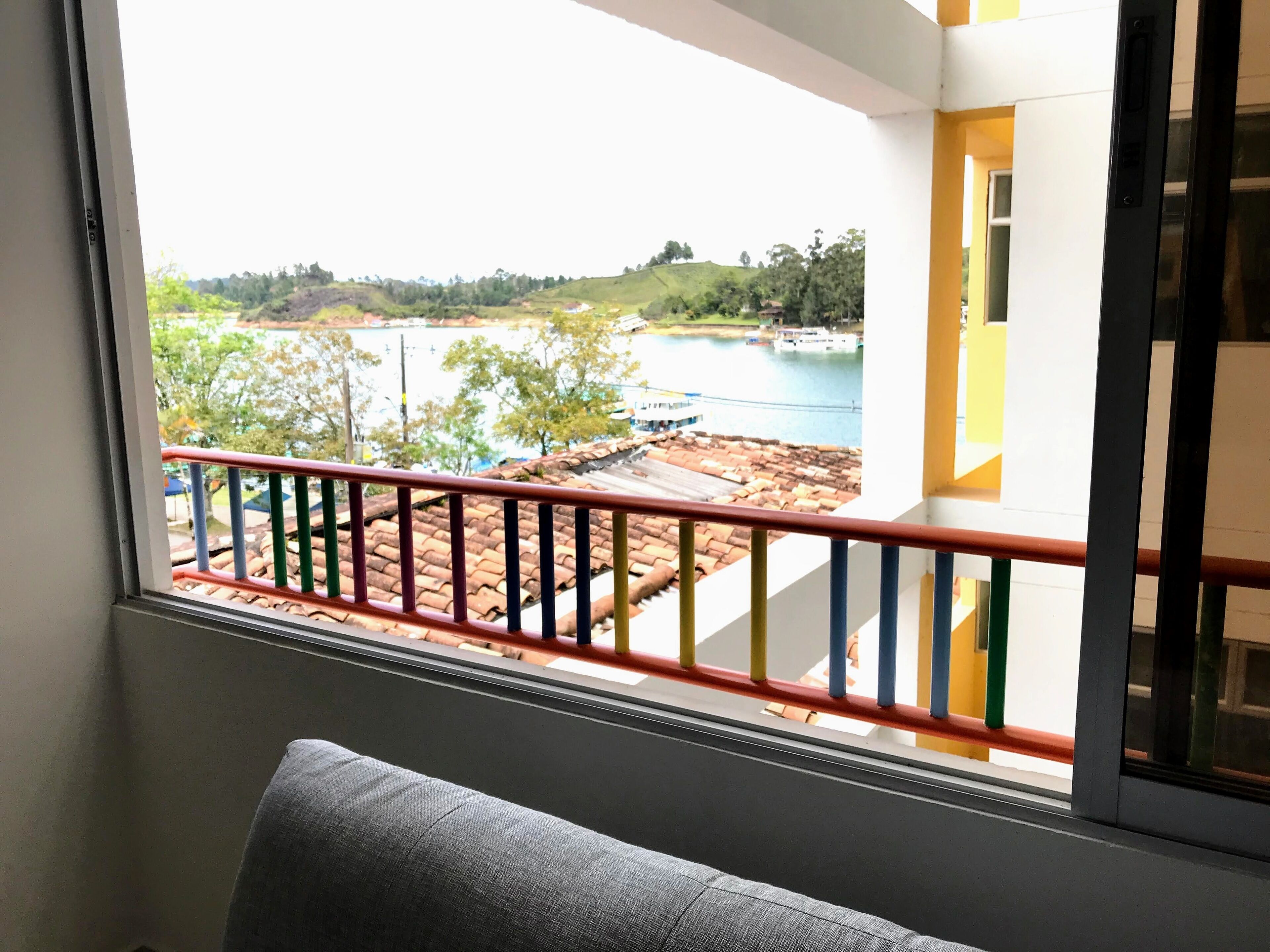 A balcony with a view of a river and hills.