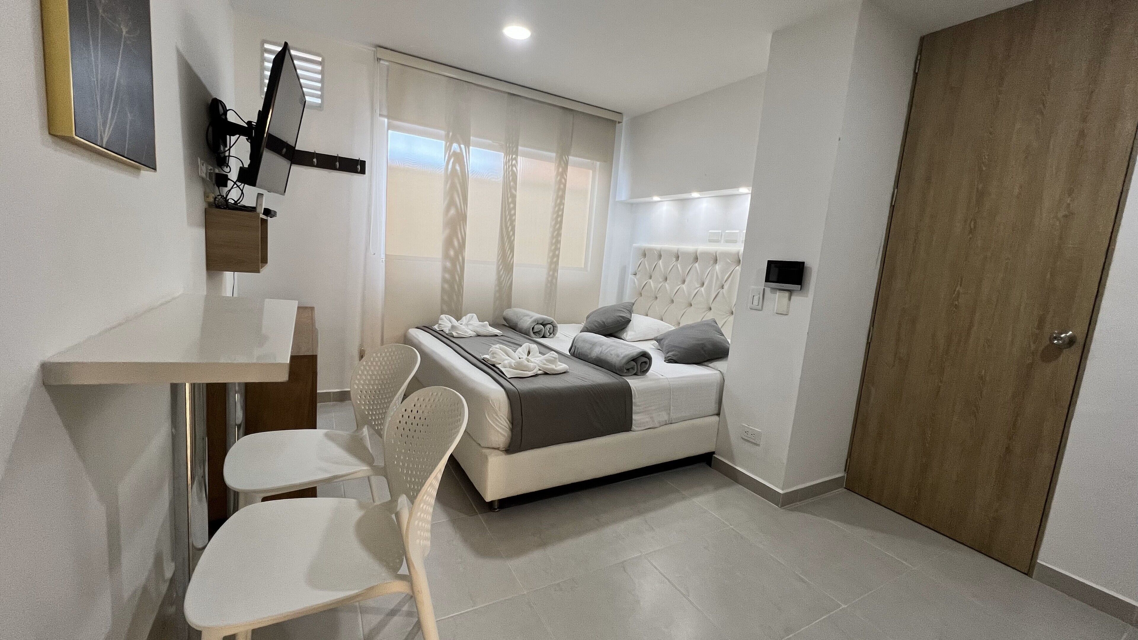 Une chambre à coucher moderne avec un lit, un bureau et une chaise.