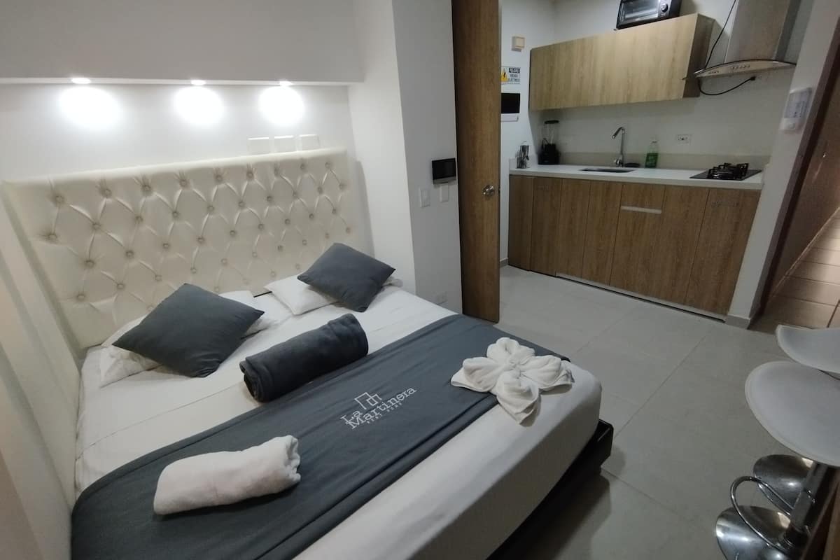 Een hotelkamer met een bed, een kitchenette en een badkamer.