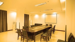 A conference room with a long table, chairs, a projector screen, and a water dispenser. - Greentree Inn Lianyungang Guanyun Bus Station Zhenxing Garden Express (Lianyungang)