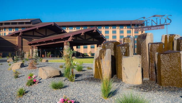 A hotel entrance with a covered patio, large rocks, and a sign for the Legends Casino Hotel. - Legends Casino Hotel (Toppenish)