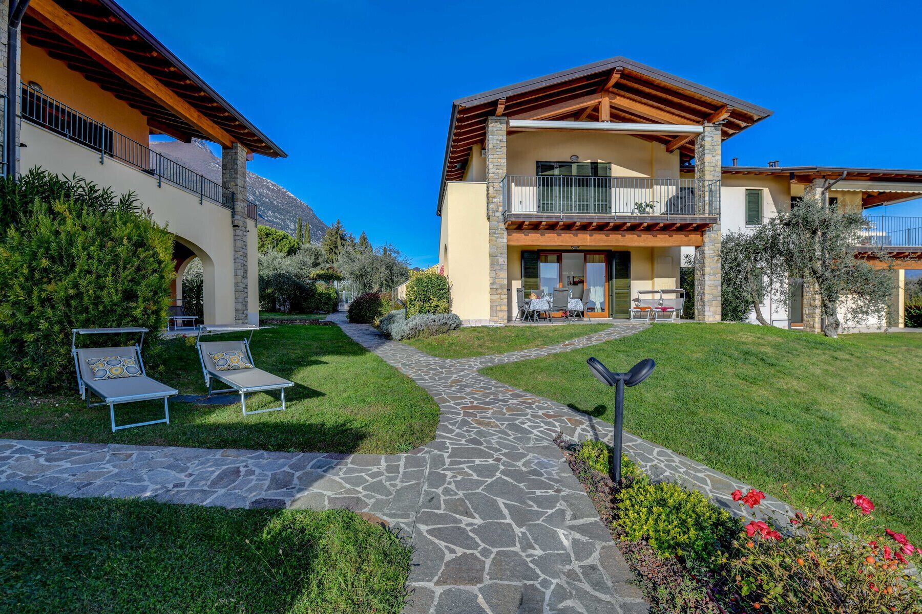Una casa de dos pisos con un camino de piedra que lleva a un patio.