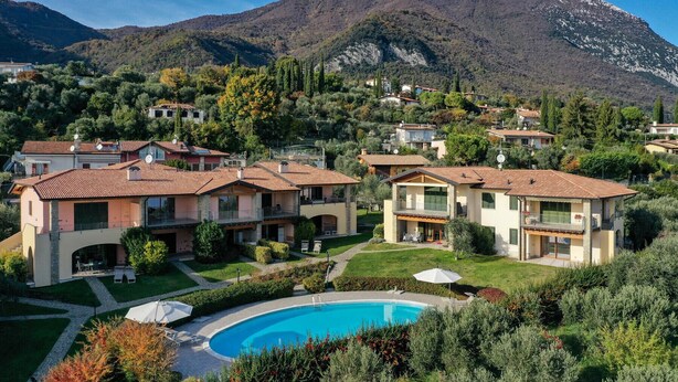 Um bairro residencial com casas, uma piscina e uma montanha ao fundo.