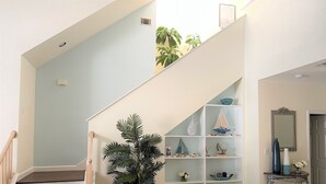 A staircase with wooden steps leading to a landing with a white railing.