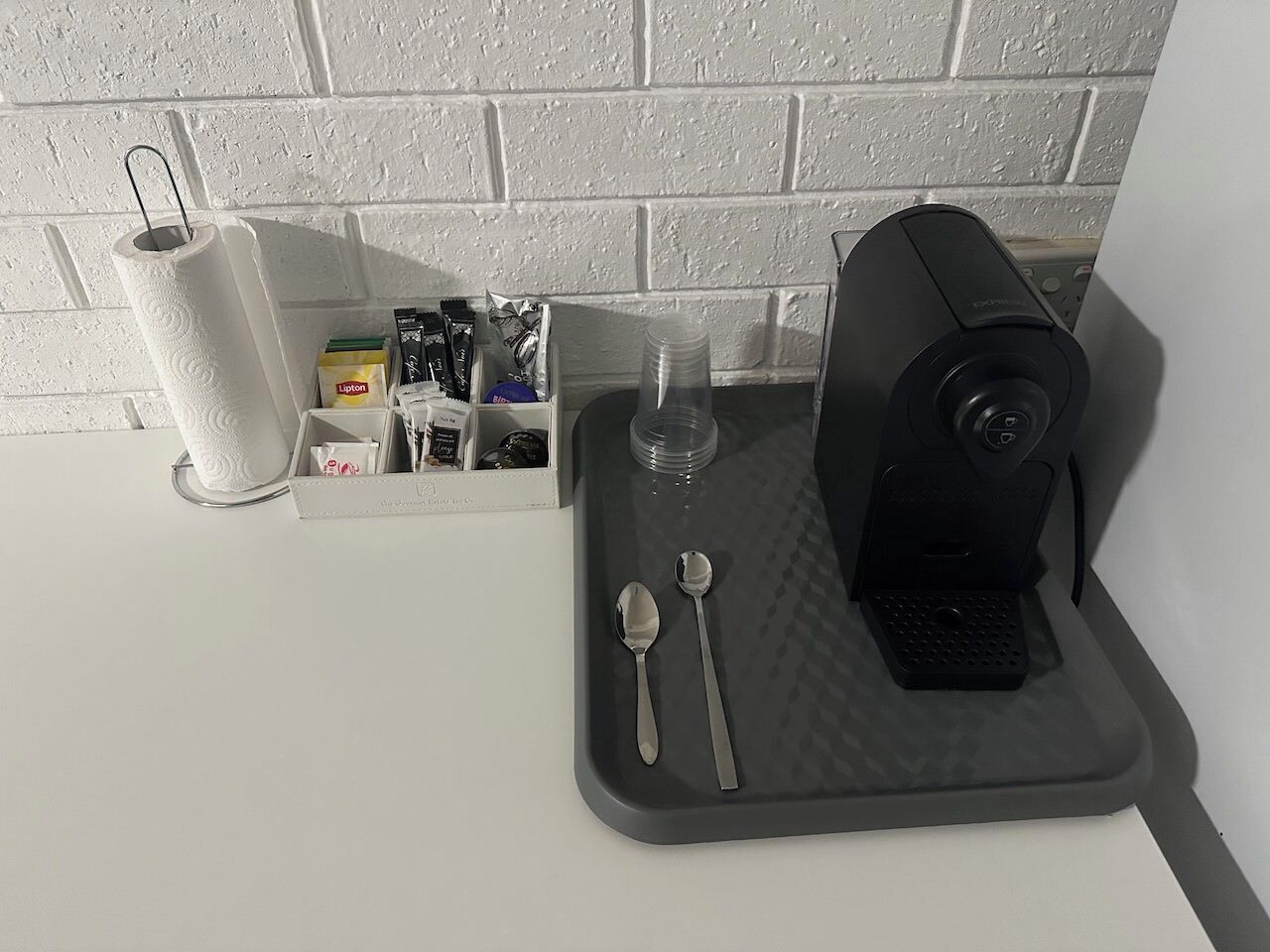 A kitchen counter with a coffee machine, a paper towel holder, and a spice rack.