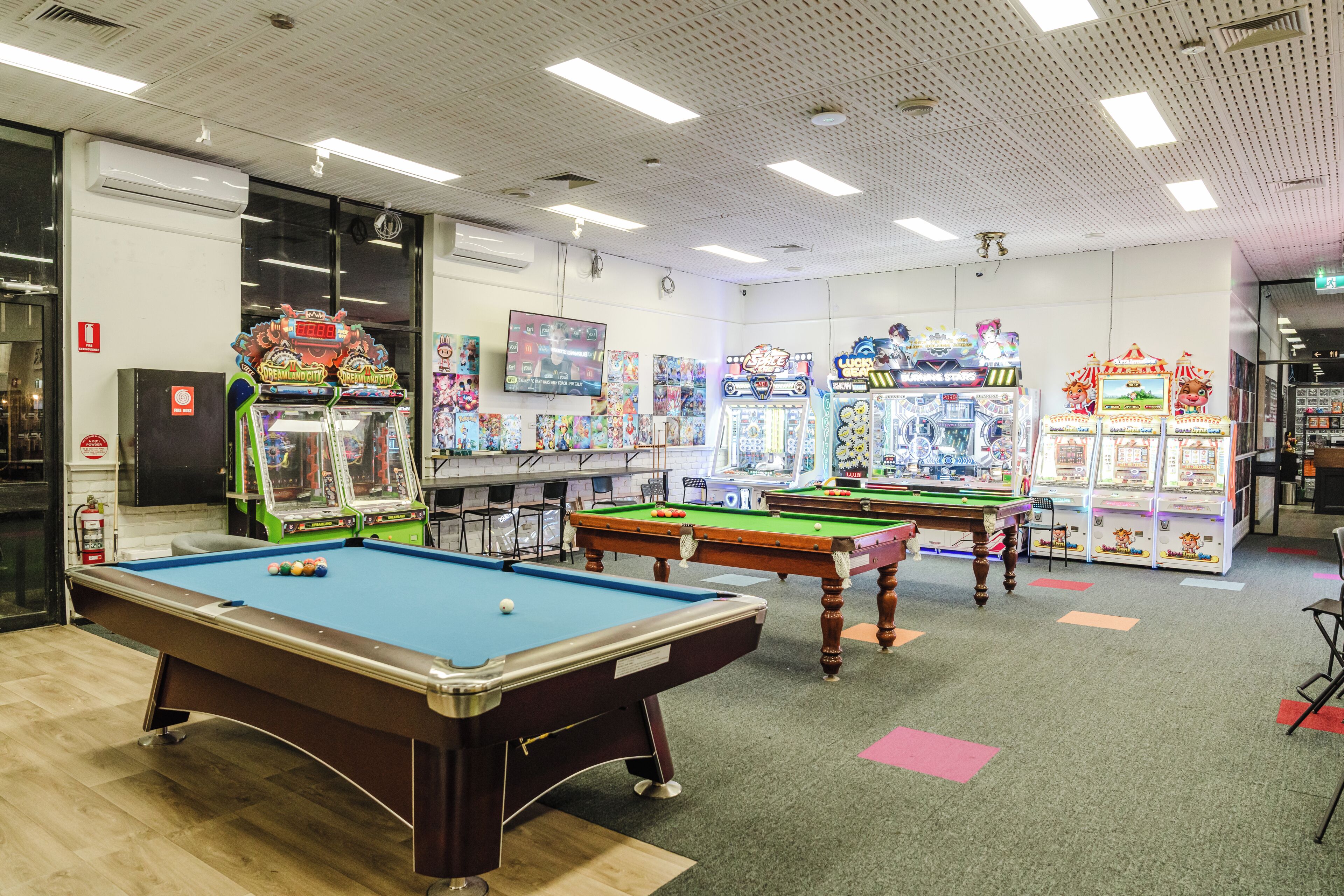 Un espace de loisirs équipé de tables de billard, de jeux d’arcade et d’un extincteur pour les lances à incendie.