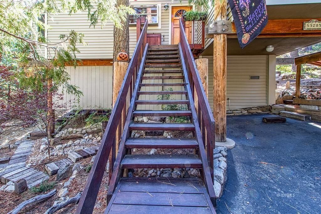 Una escalera de madera que conduce a una casa con un porche.