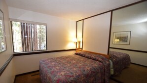 A bedroom with a single bed, a nightstand, a mirror, and a window with blinds. - Beautiful Sleep 6 condominium at CLUB TAHOE, in Incline Village Nevada. (Incline Village)