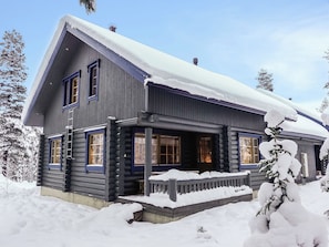 A log cabin with a snow-covered roof and a wooden porch. - Lomapykälä 1 a by Interhome (Kittilä)
