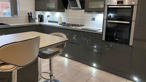 A modern kitchen with stainless steel appliances, a gas stove, and a Bosch oven. - 4-bed House With Private Garden in Barnsley! (Barnsley)