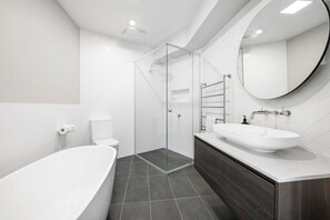 Bathtub, hair dryer, towels, shampoo