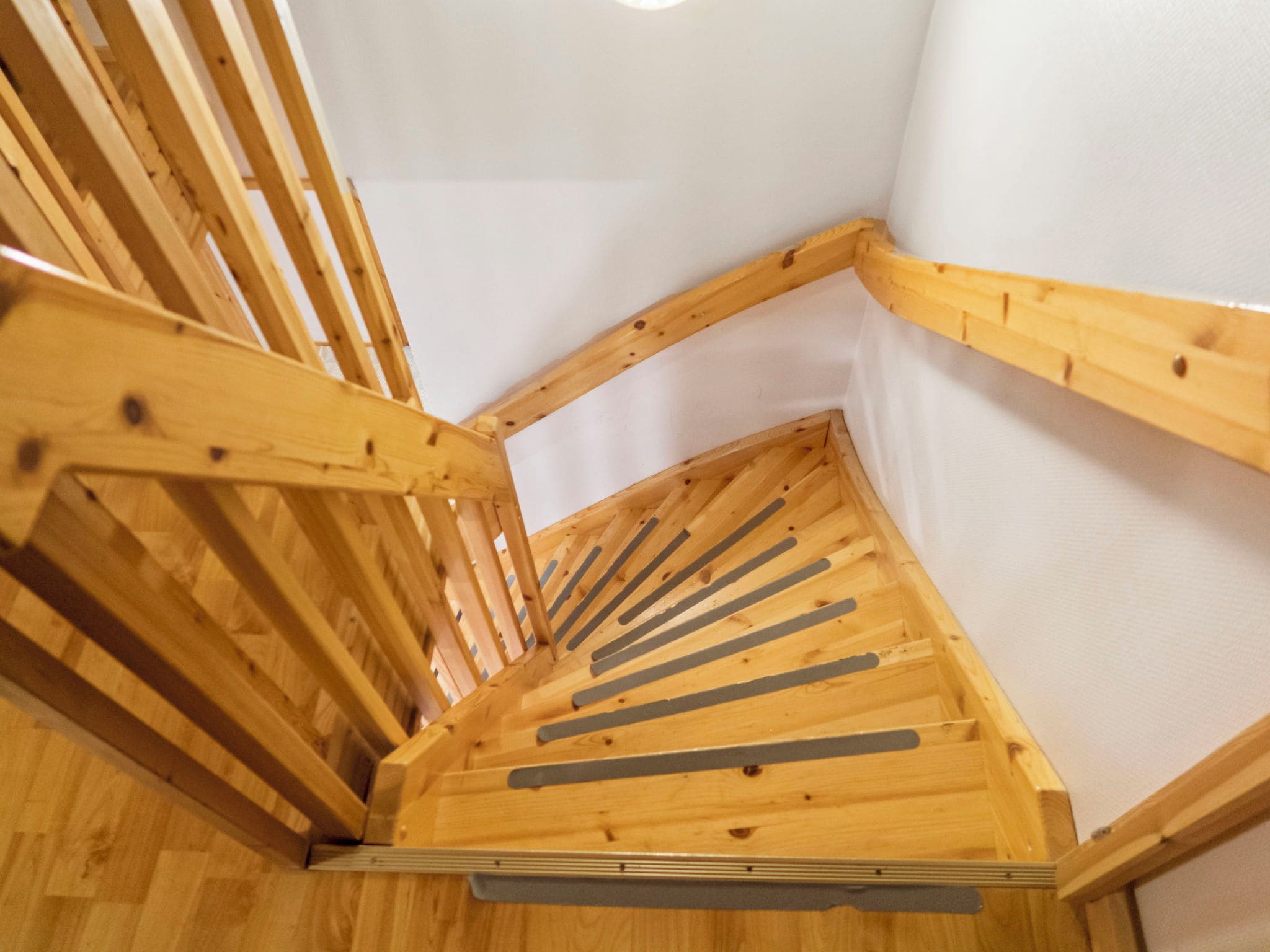 Een houten trap met een leuning en een plateau.