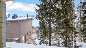 Un hotel con vista a árboles nevados y un edificio con un letrero.