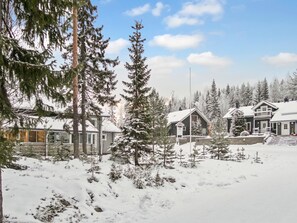 A snow-covered landscape with a lodge featuring a large porch and multiple buildings.
