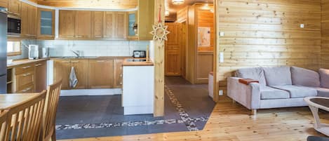 Un intérieur en bois comprenant une cuisine, un coin repas et un espace de vie.