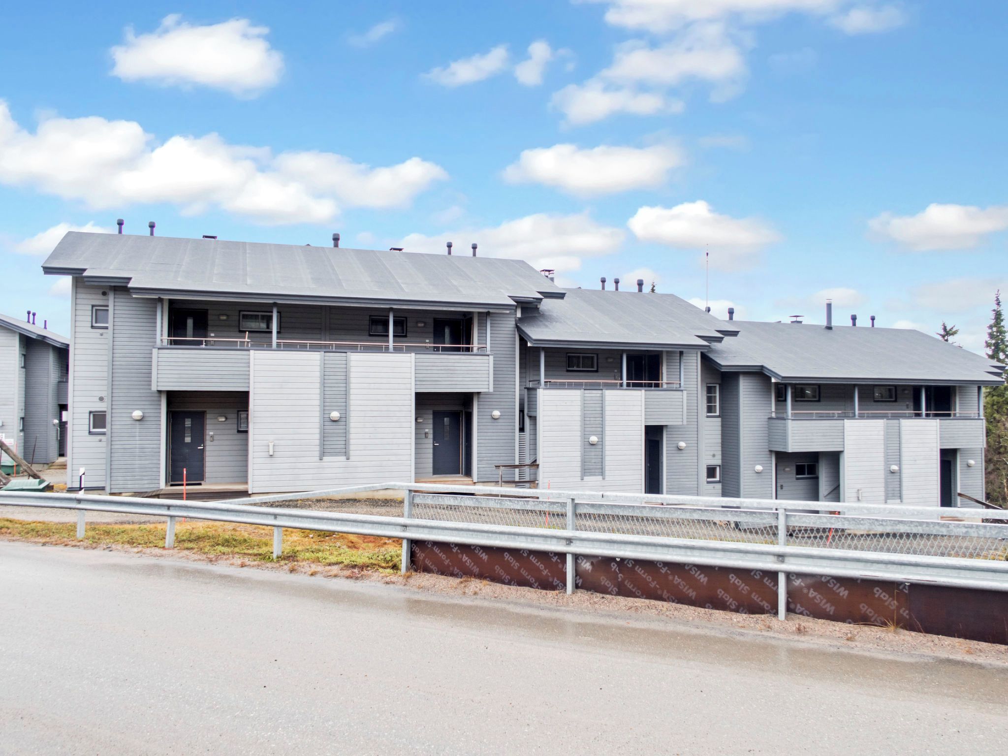 Un bâtiment moderne à plusieurs étages, doté d’un toit plat, de grandes fenêtres et d’un espace d’entrée abrité.