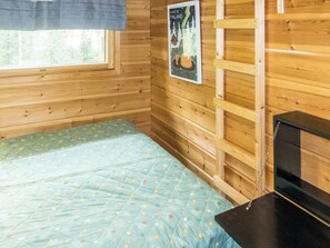 A wooden cabin room with a bed, a window, and a poster on the wall. - Sinikuono by Interhome (Ylläsjärvi)