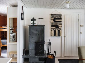 A room with a fireplace, a door, and a wall-mounted clock.
