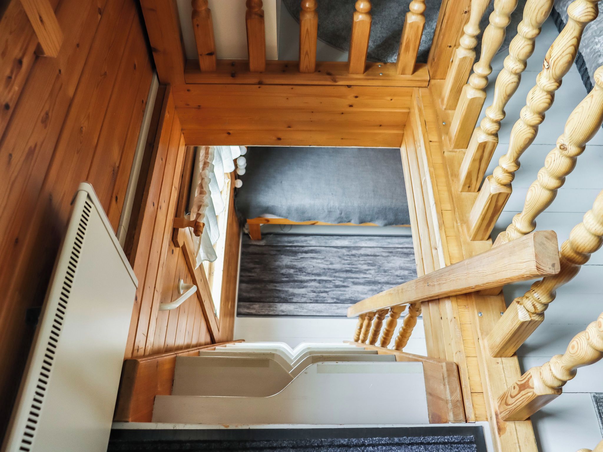 A wooden staircase with a handrail leading to a landing.