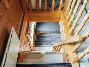 Una escalera de madera con barandilla que lleva a una plataforma.