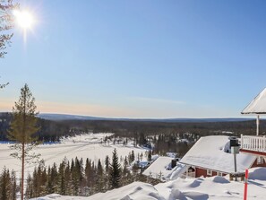 Un paysage enneigé avec une cabane et un ciel dégagé.