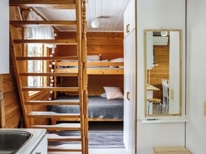 A compact room with bunk beds, a small kitchen area, and a mirror. - Iso kiiruna by Interhome (Hyrynsalmi)