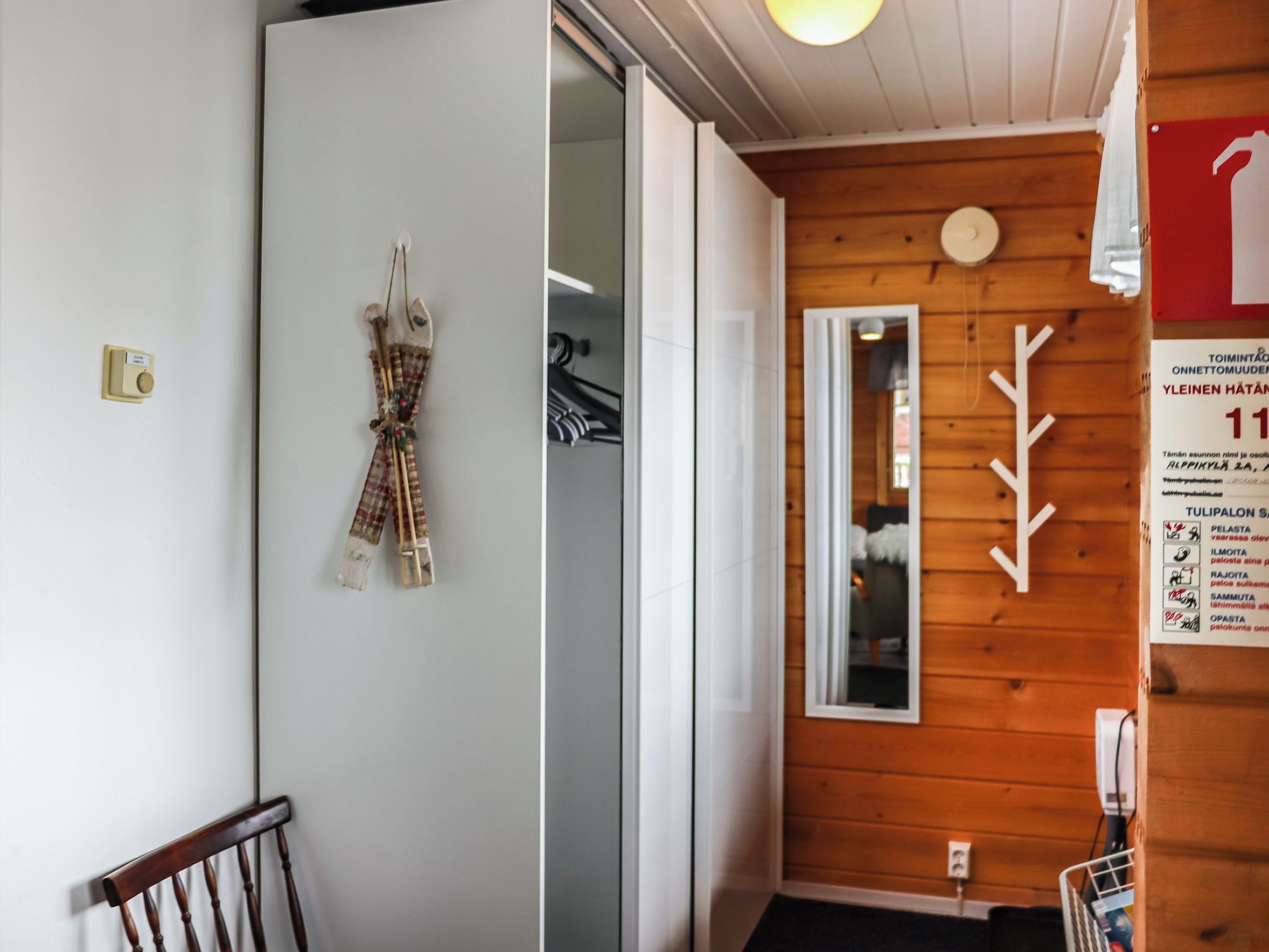 Une pièce avec un mur en bois, un miroir et une porte.