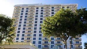 Un hotel de varios pisos con fachada uniforme, balcones y cielo despejado.