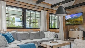 A modern living room with a sectional sofa, a coffee table, and a television mounted on the wall.
