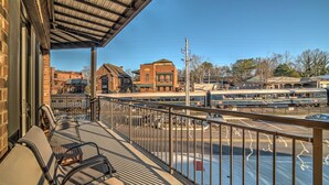 A balcony with a view of a train station and buildings in the background.