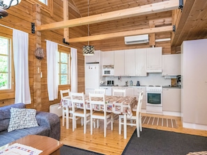 A cozy cabin interior with a dining area, kitchen, and seating space.