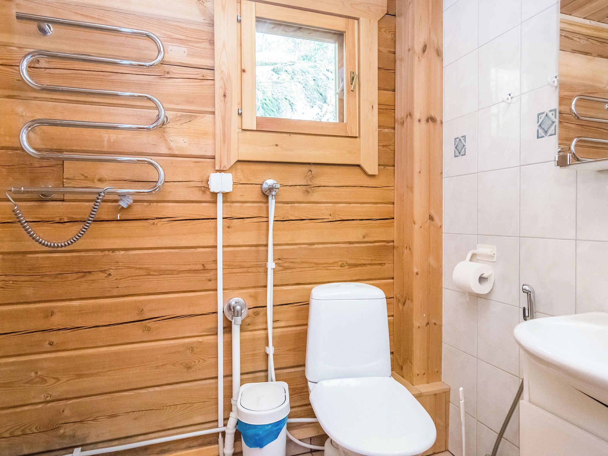 A wooden interior with a toilet, bidet, and shower.
